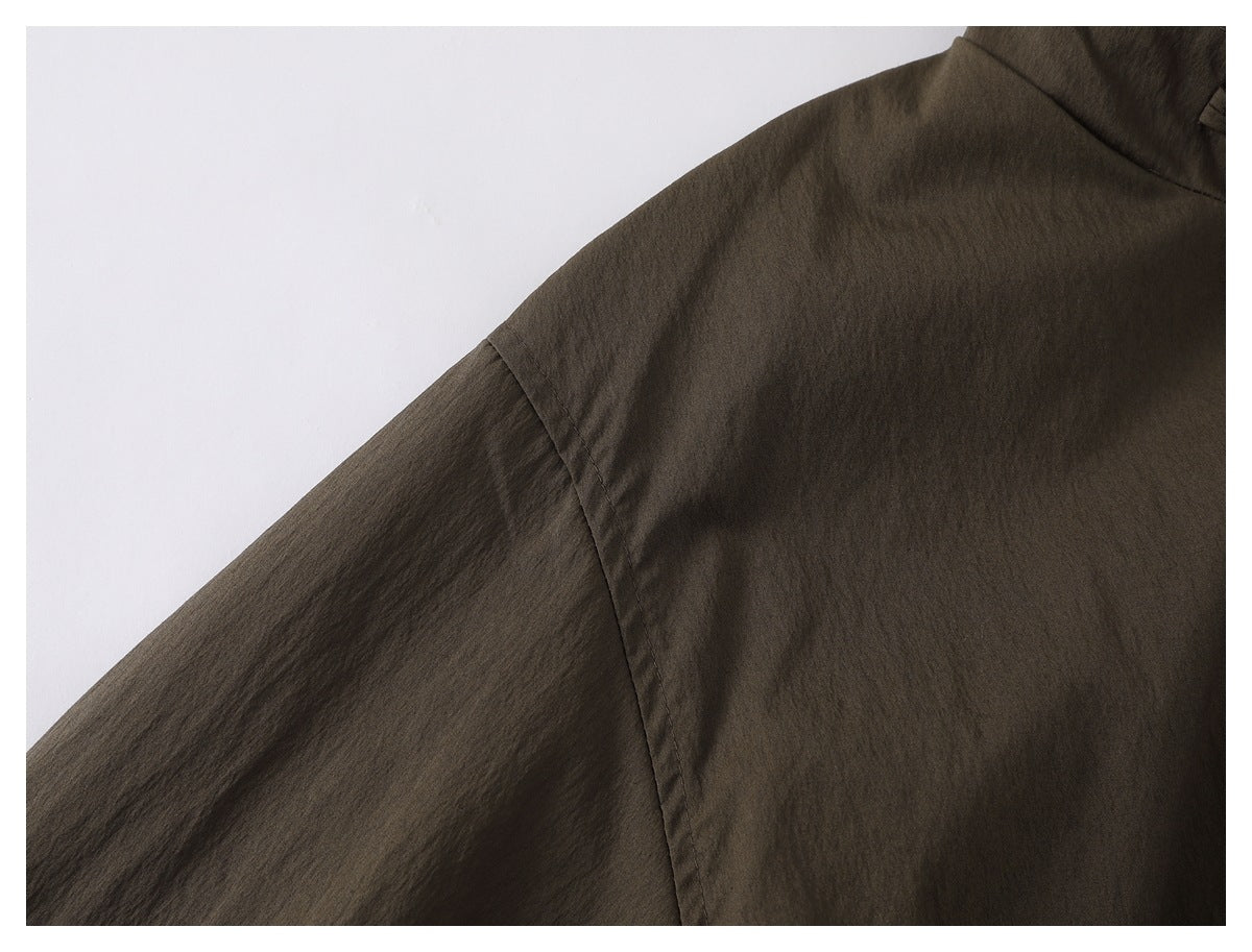 Close-up of the dark olive-brown jacket’s sleeve and shoulder seam.