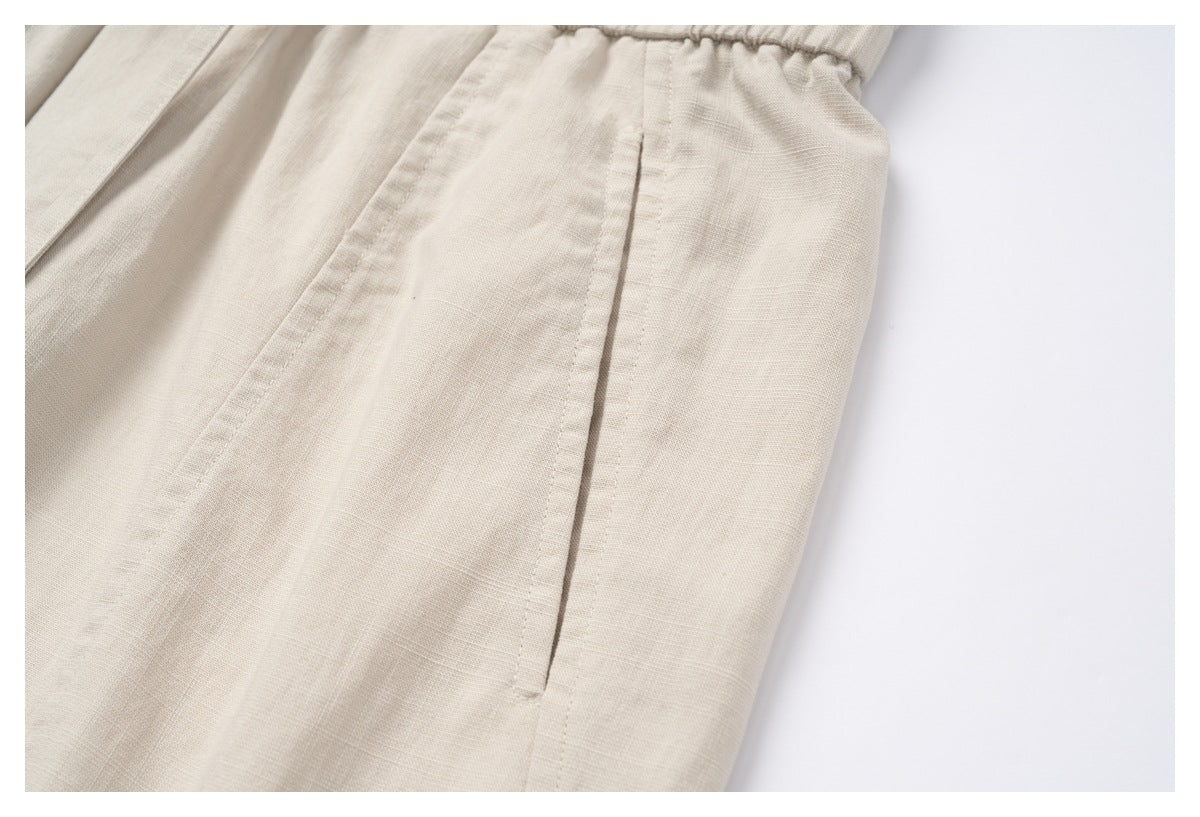 Close-up of a cream garment's elastic waistband and stitched side pocket opening.