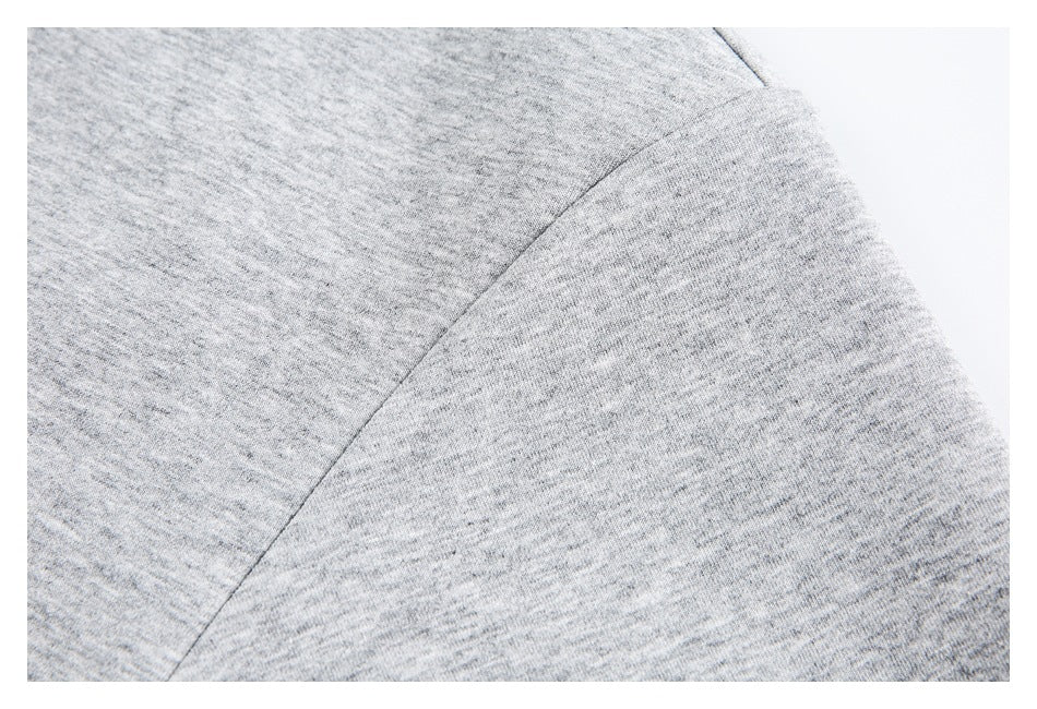 Close-up of a curved seam on the heather-gray shirt fabric.