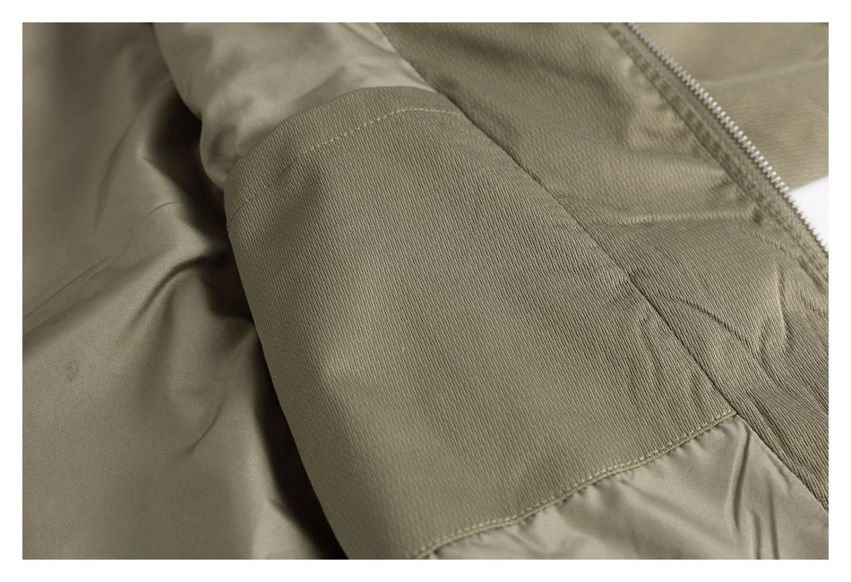 Close-up of an olive sleeve with a broad ribbed cuff beside the open zipper.
