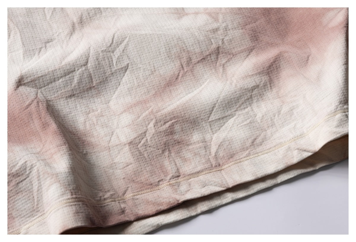 Close-up of the shirt's lower hem stitching against its muted cream, gray, and dusty-rose pattern.