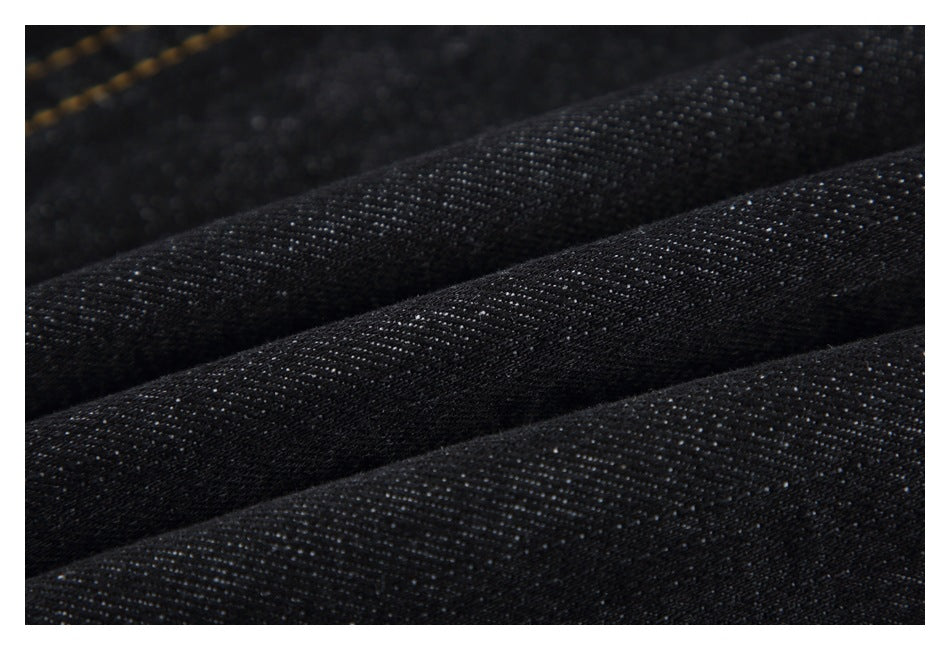 Close-up of black textured fabric arranged in long, parallel folds.