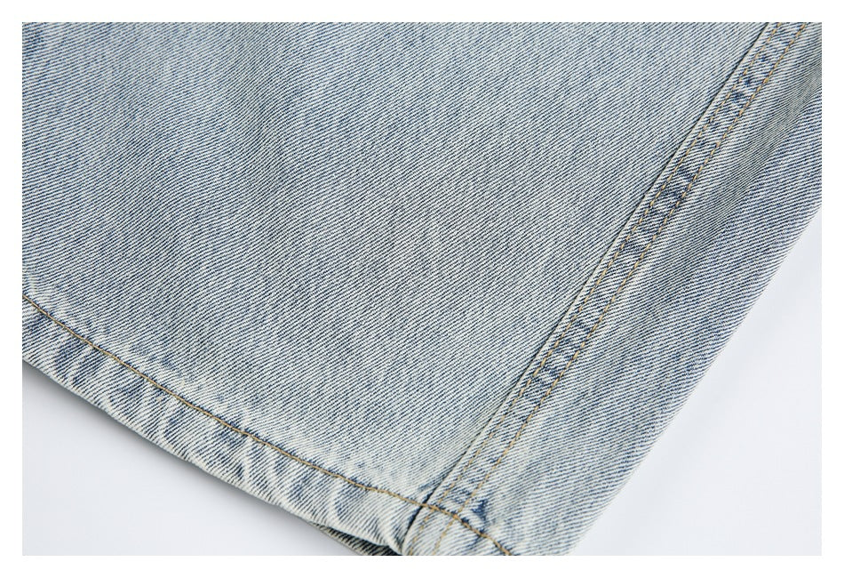 Close-up of light-wash jeans showing a leg hem and double-stitched side seam.