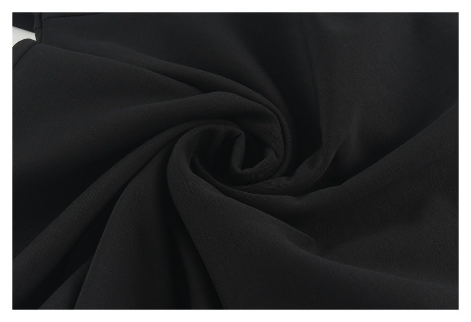 Black fabric gathered into a spiral of folds, shown in close-up.