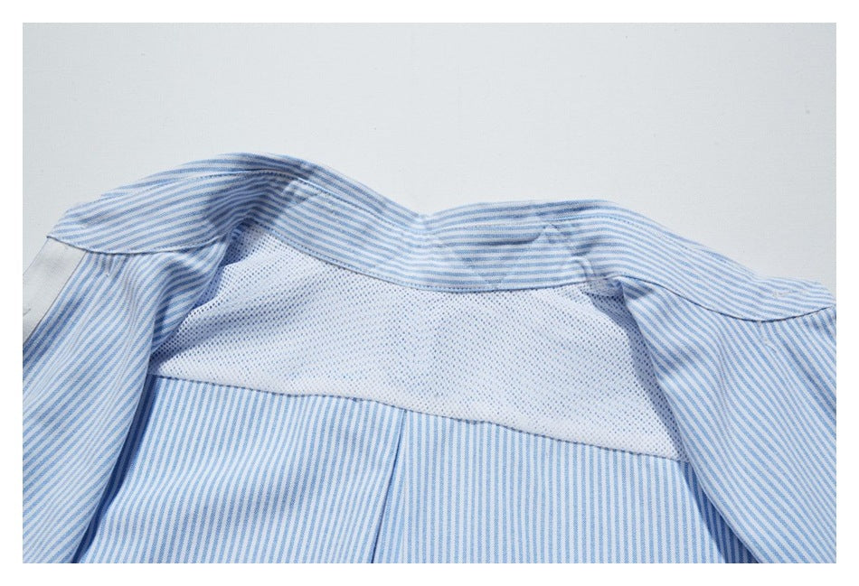 Close-up of the inside of a blue-and-white striped shirt, showing a white mesh panel across the upper back.
