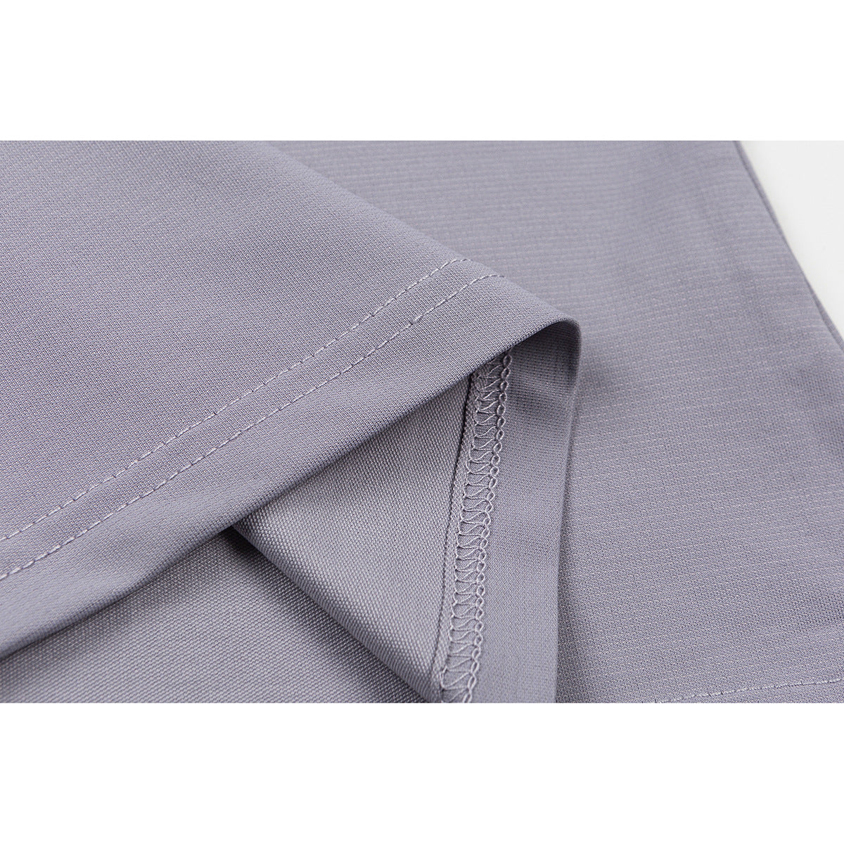 Close-up of the lavender-gray T-shirt hem, showing double stitching and the overlocked side seam.