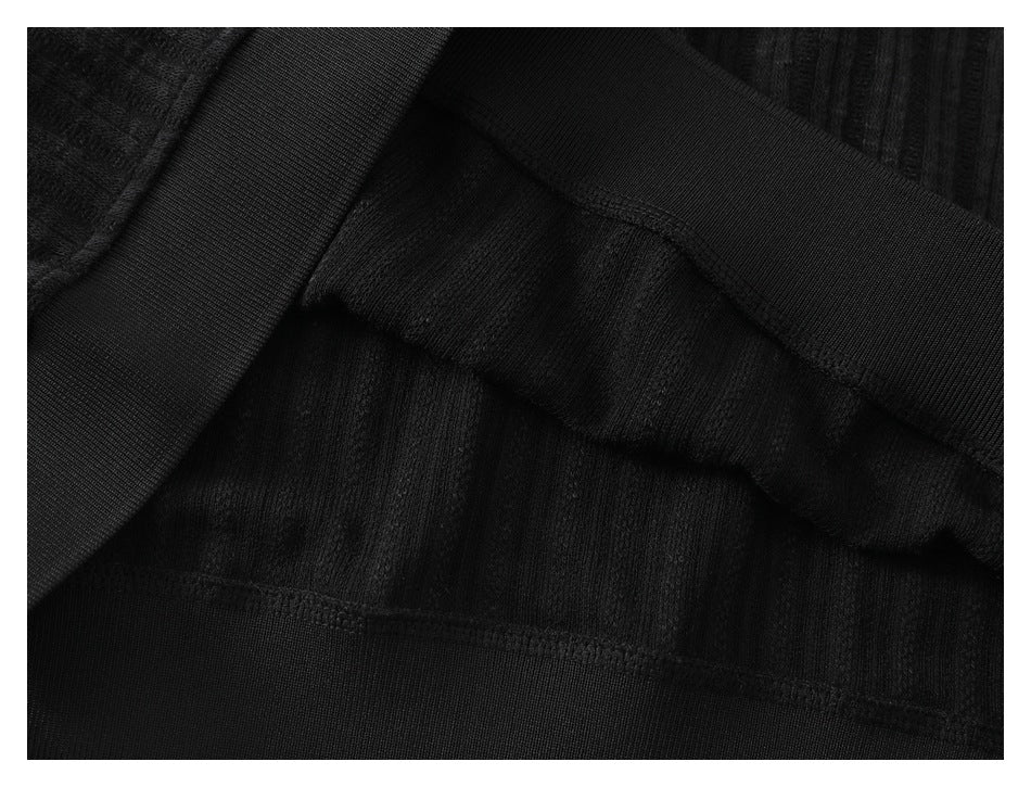 Close-up of the black garment's inner seam and ribbed fabric construction.