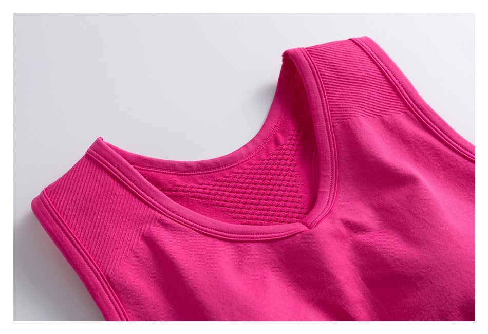 Close-up of a bright fuchsia sports bra showing its scoop neckline, broad straps, and perforated back panel.
