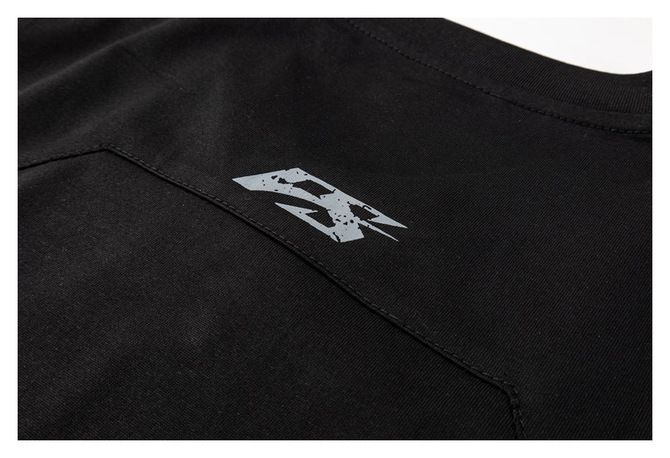 Close-up of a black shirt's back panel, showing a small gray graphic and curved seam.