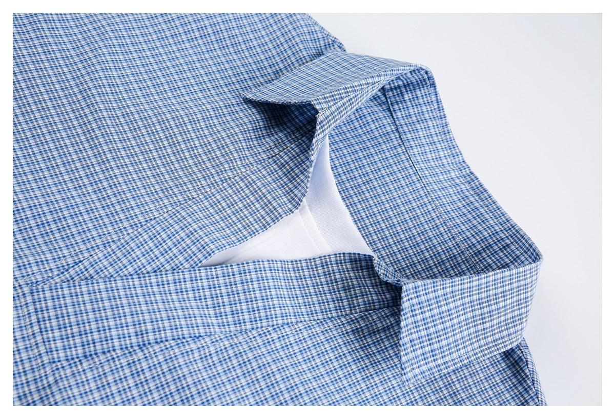 Close-up of the checked shirt's open collar and neckline, with a white undershirt visible beneath.