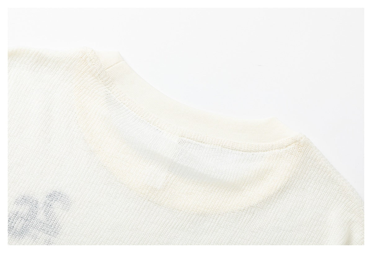 Close-up of the back neckline and shoulder seam of an ivory knit shirt.