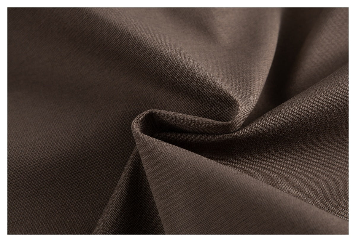 Macro view of brown garment fabric folded to show its fine textured surface.