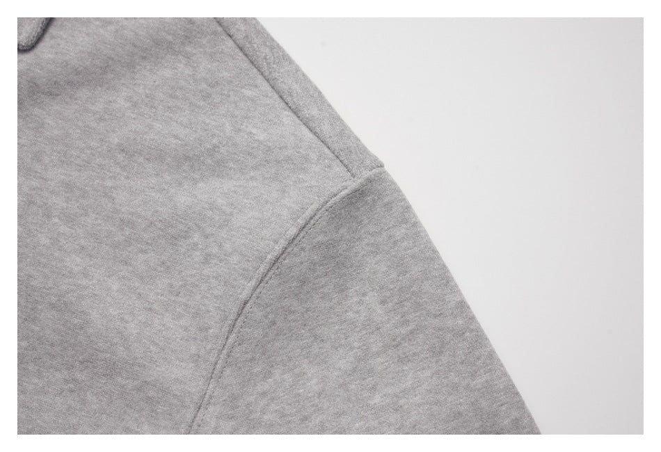 Close-up of a light gray top's shoulder seam and sleeve join.