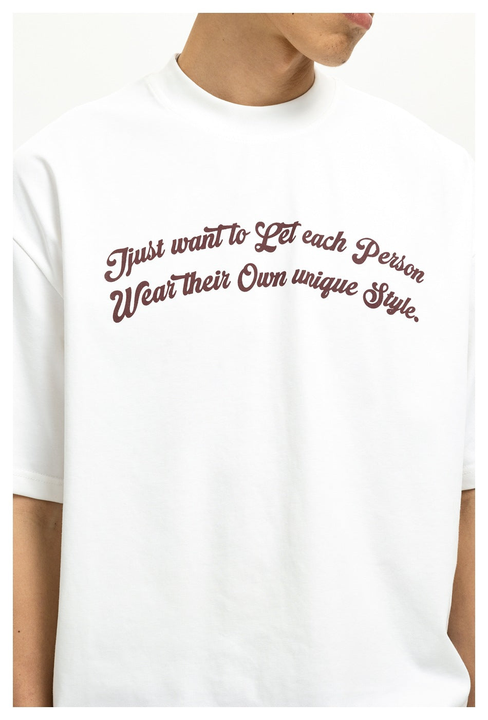 Close-up of a model wearing a white crew-neck T-shirt with arched burgundy script across the chest.