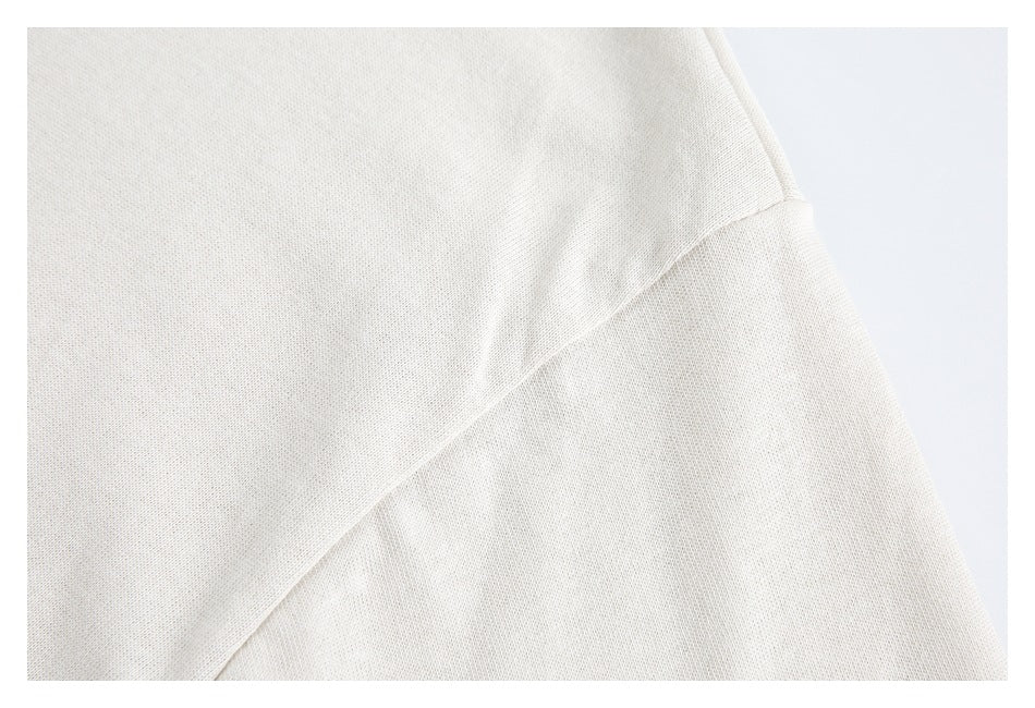 Close-up of the off-white shirt’s shoulder and sleeve seam.