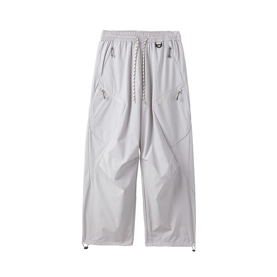 Light gray-white wide-leg drawstring pants with diagonal zip pockets and toggle hems, front flat view