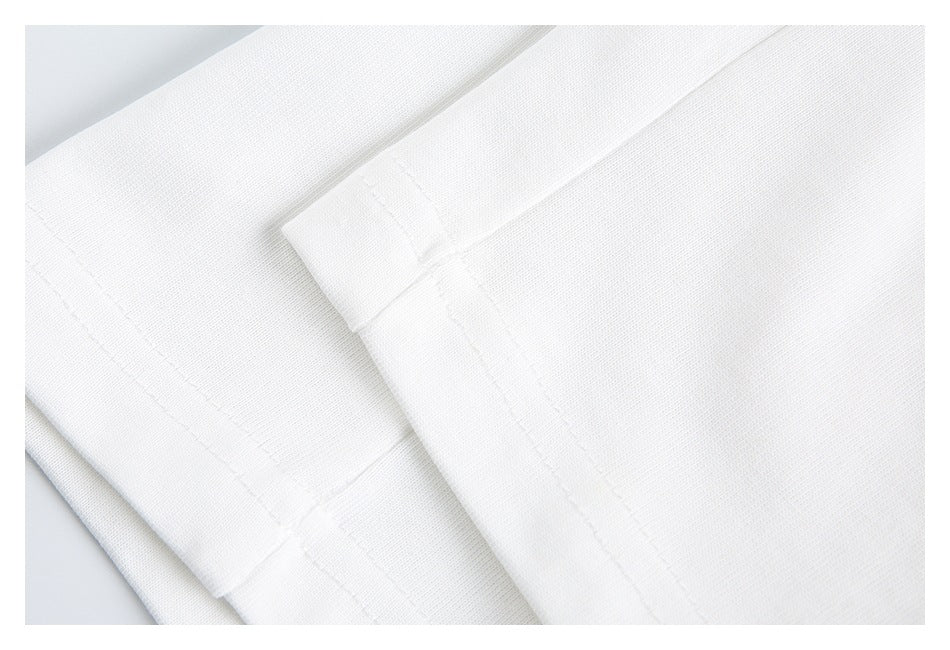 Close-up of white garment fabric with overlapping stitched panels and a seam.