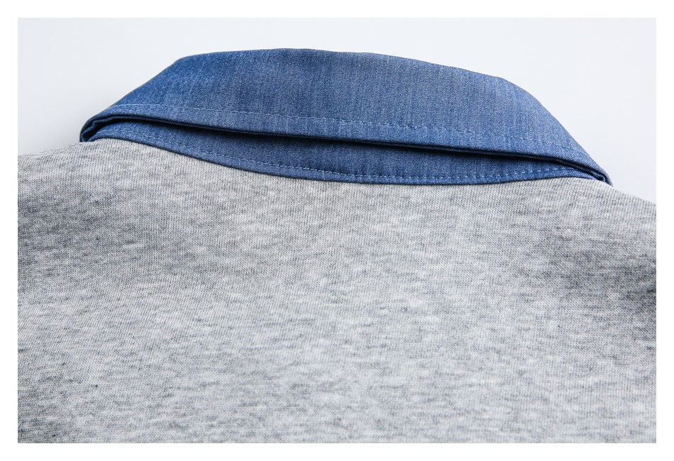 Close-up of a gray heathered garment with a contrasting blue folded collar.