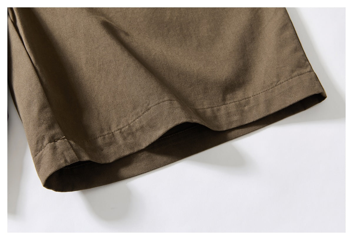 Close-up of the stitched hem on brown trouser legs.