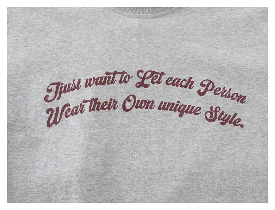 Close-up of burgundy script text printed across the chest of a heather gray T-shirt.