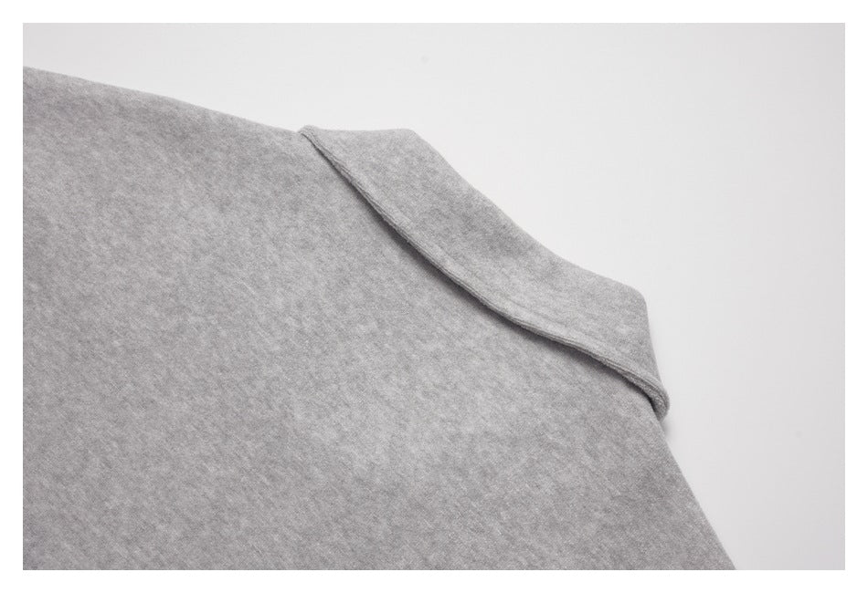 Close-up of a gray garment's folded shoulder or neckline edge and stitching.