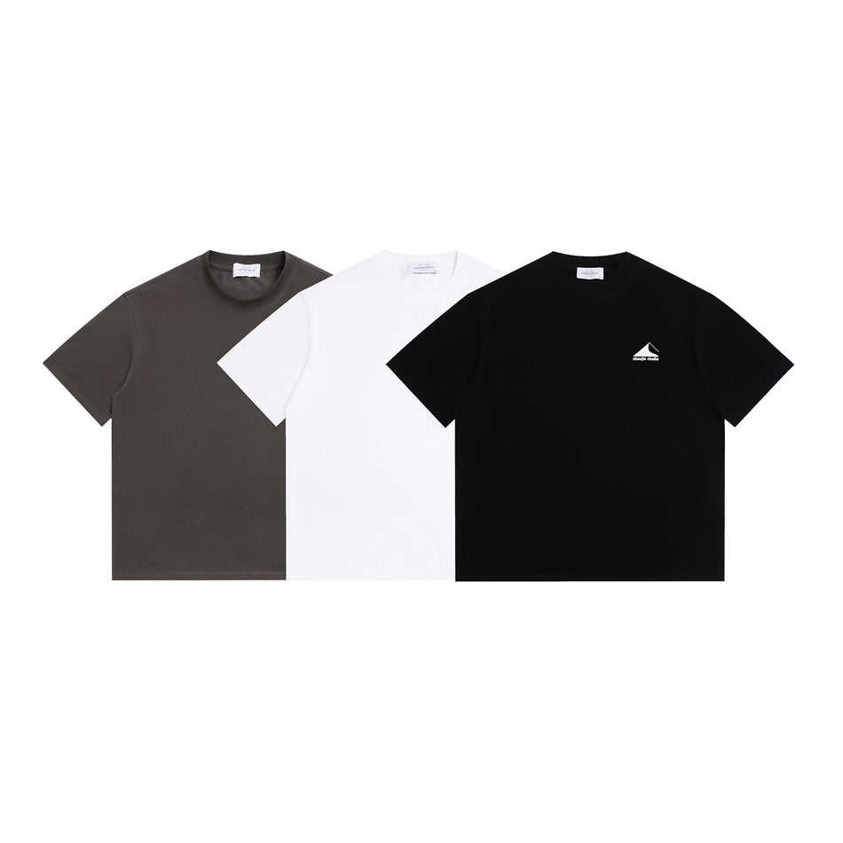 Front views of three crew-neck T-shirts in charcoal gray, white, and black; the black shirt has a small chest logo.