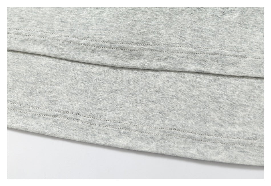 Close-up of the double-stitched lower hem of a heather-gray garment.