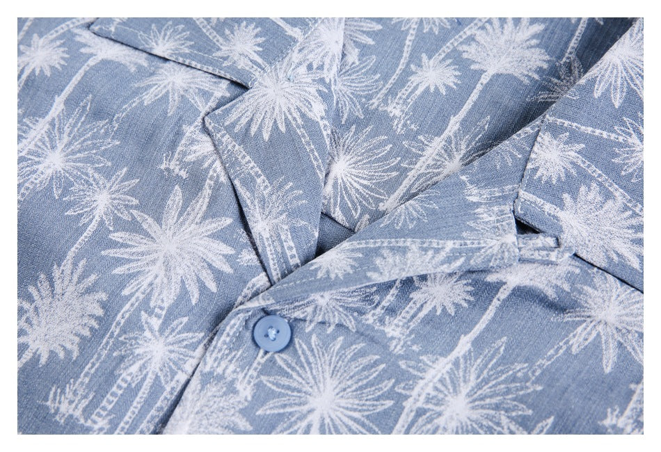 Close-up of the blue shirt’s collar, lapels and a blue button against its white palm-tree print.