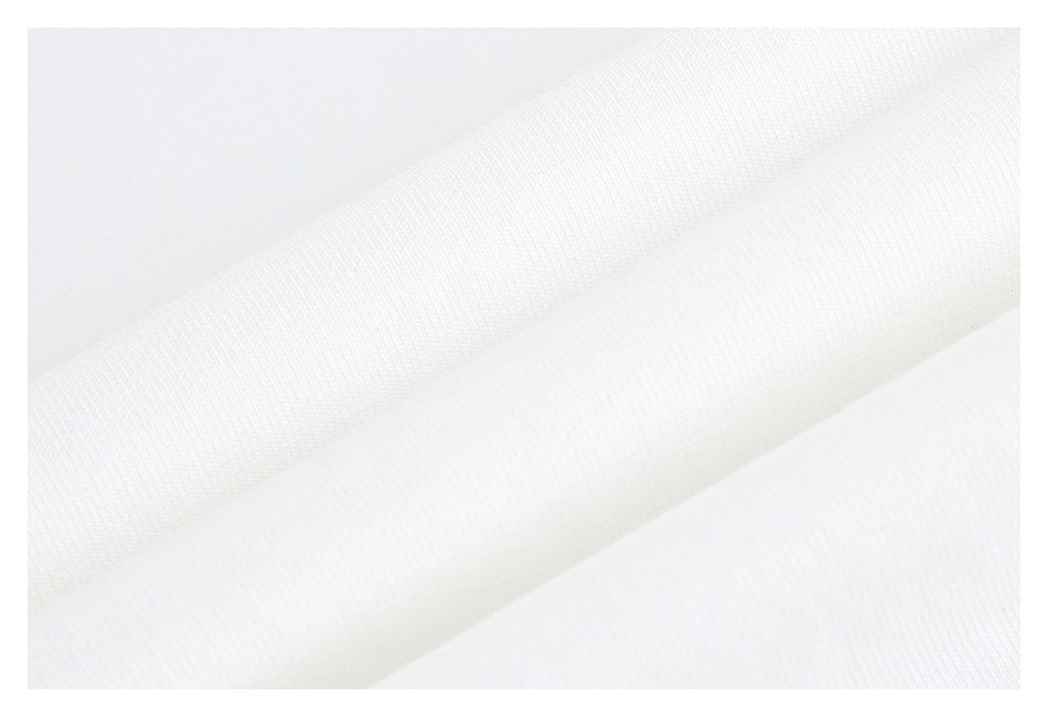 Close-up of white fabric showing its fine knit texture and folded layers.