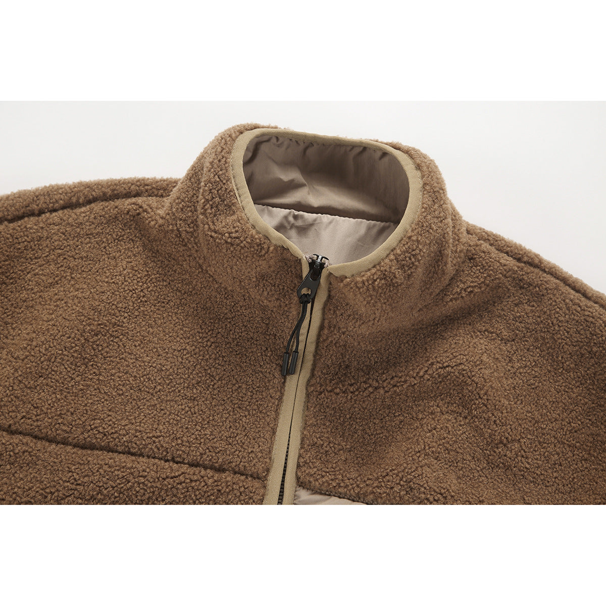 Close-up of a brown textured fleece jacket collar and front zipper with tan trim and lining.