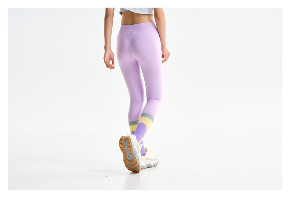 Close rear view of lilac leggings with gray, yellow, and purple color-blocking at the calves.