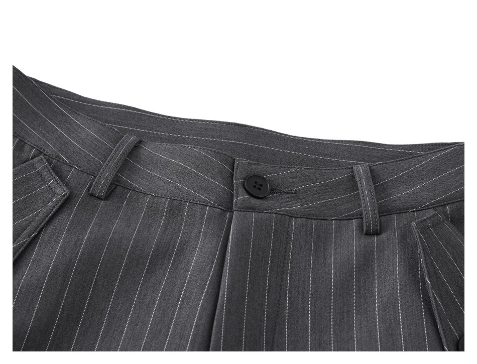 Close-up of the charcoal pinstripe trousers' waistband, button, belt loops, and pleats.
