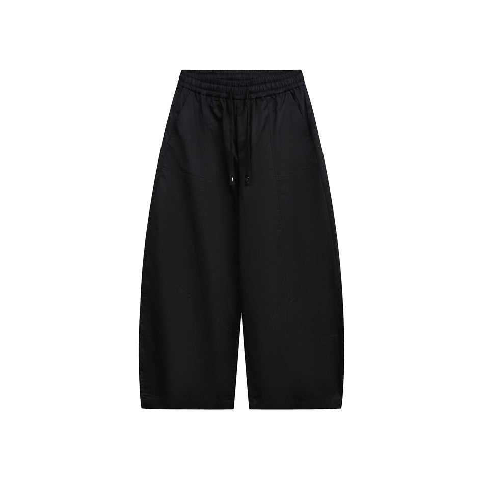 Black wide-leg drawstring pants with elastic waistband and barrel-shaped legs, front flat view