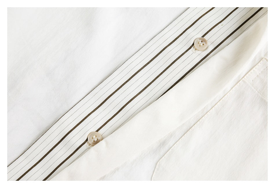 Close-up of an ivory garment’s button placket with two cream buttons and narrow brown stripes.