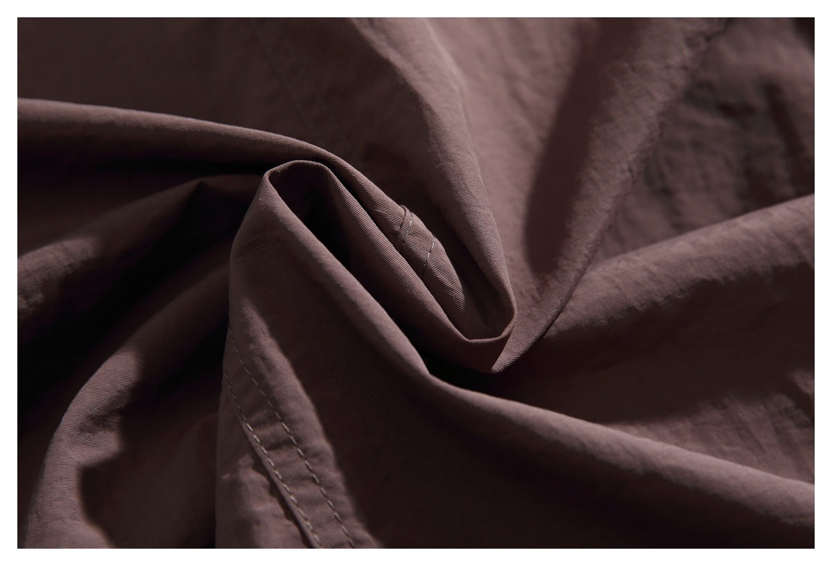 Close-up showing the brown jacket fabric folded to reveal its texture and stitched edge.