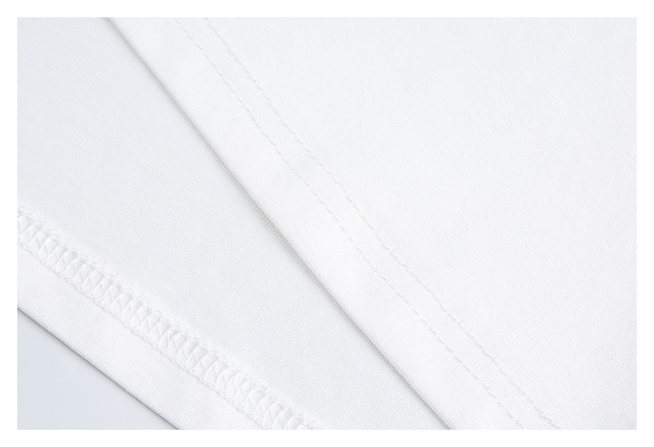 Close-up of white T-shirt fabric and finished stitching along a garment edge.