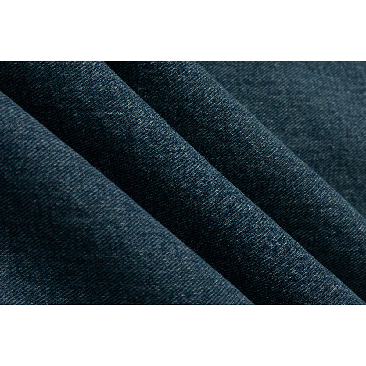 Extreme close-up of the jacket's dark blue denim surface and diagonal weave.