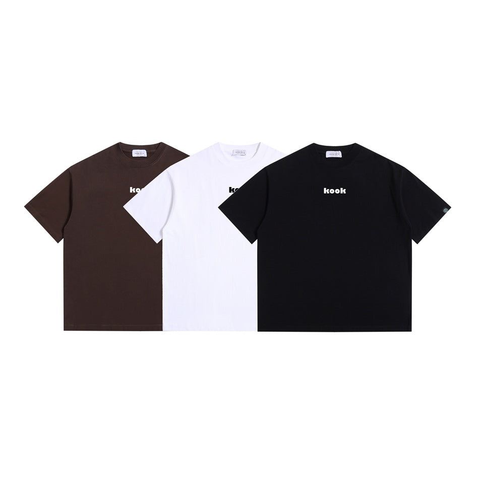 Three short-sleeve crew-neck T-shirts shown from the front in brown, white, and black, each with a small “kook” chest print.