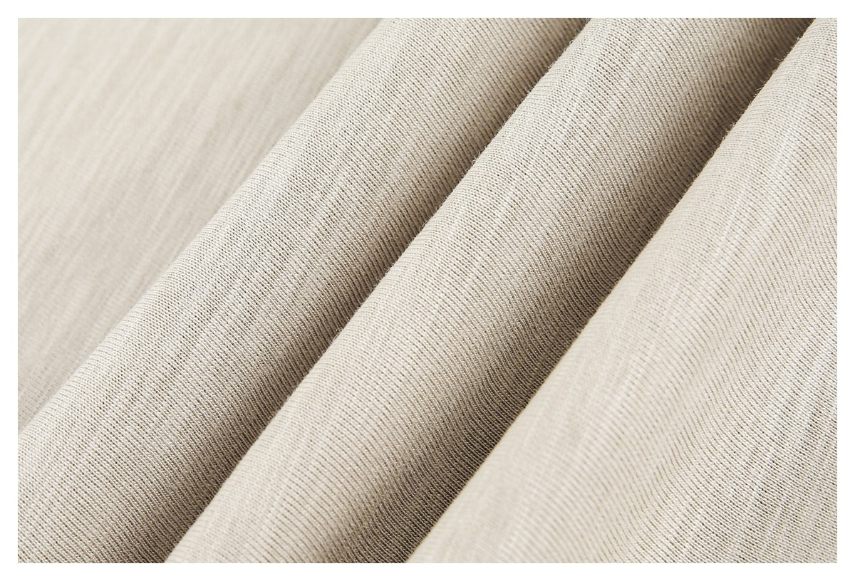 Close-up of beige heathered fabric draped in folds, showing its fine knit texture.