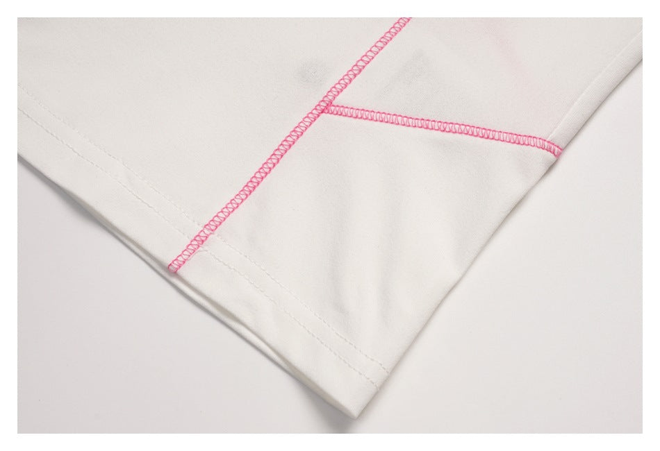 Close-up of pink overlock stitching along seams on the white top.