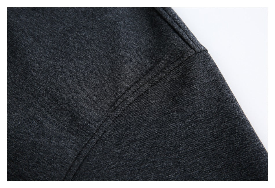 Close-up of a charcoal heather garment showing a curved stitched seam.