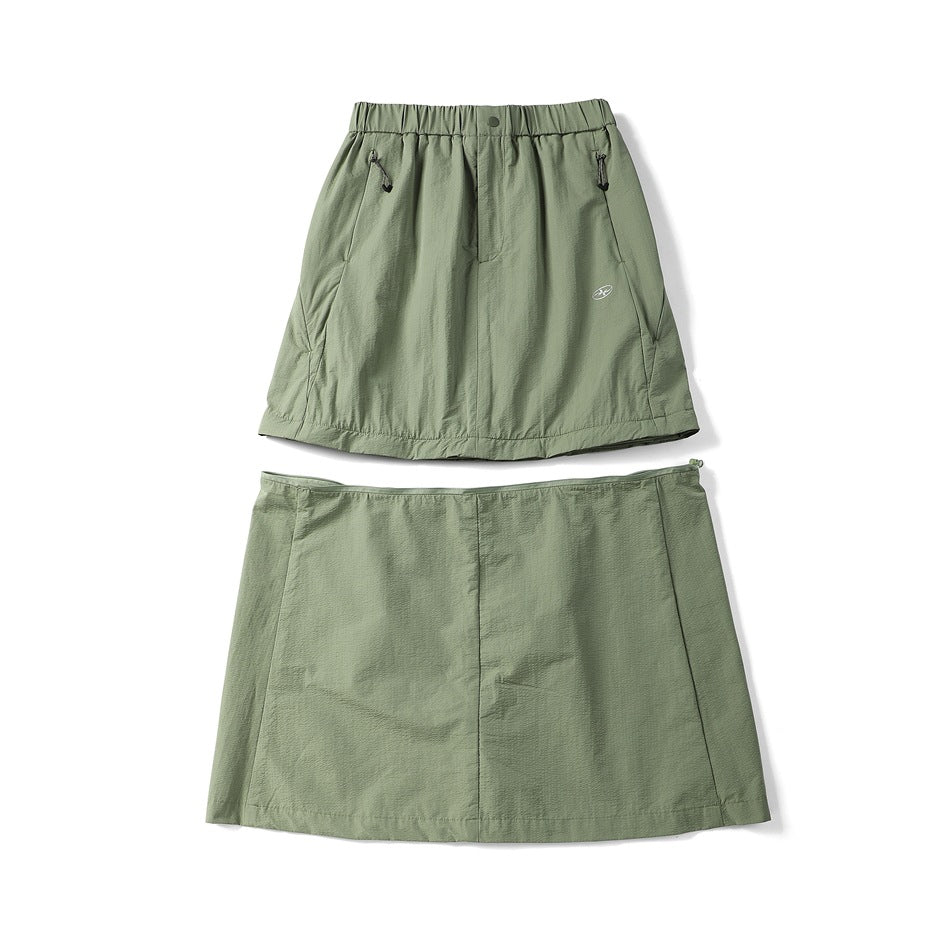 Sage green skirt shown from the front and back on a white background; the front has an elastic waist and zip pockets.