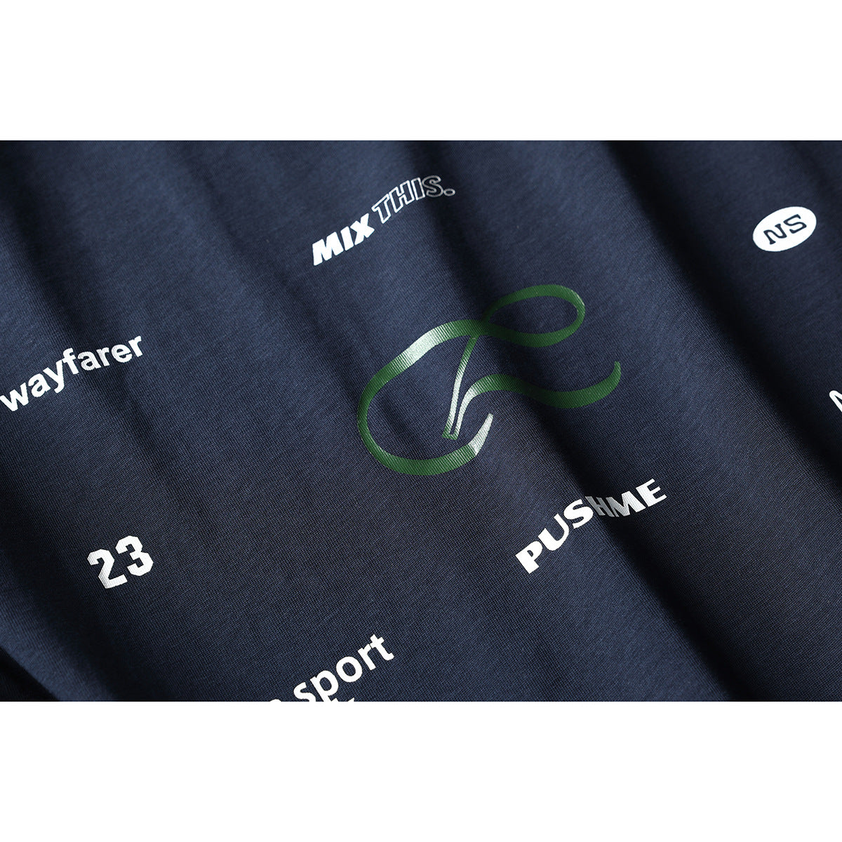 Close-up of a dark navy shirt with assorted white text and a green graphic printed on the fabric.