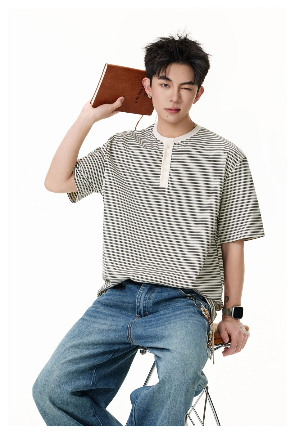 Model wearing an ivory and black striped short-sleeve henley with blue jeans.