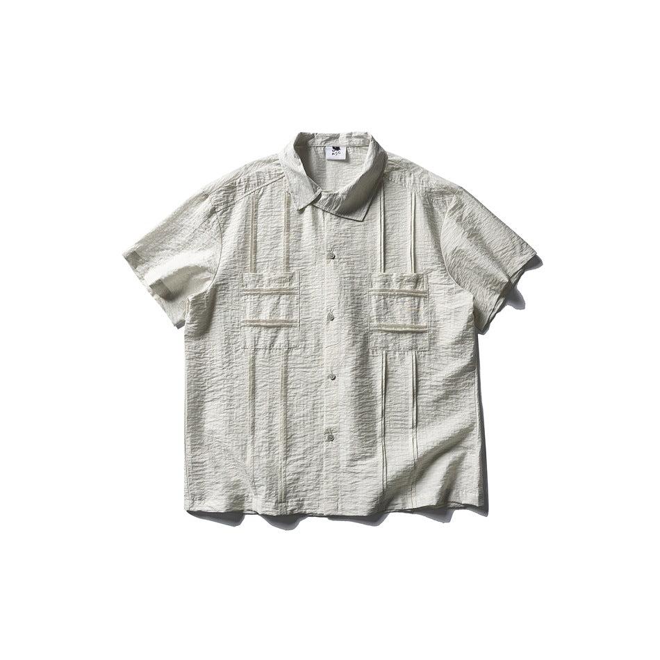 Apricot short-sleeve textured button-up shirt with two pleated chest pockets, flat lay front view