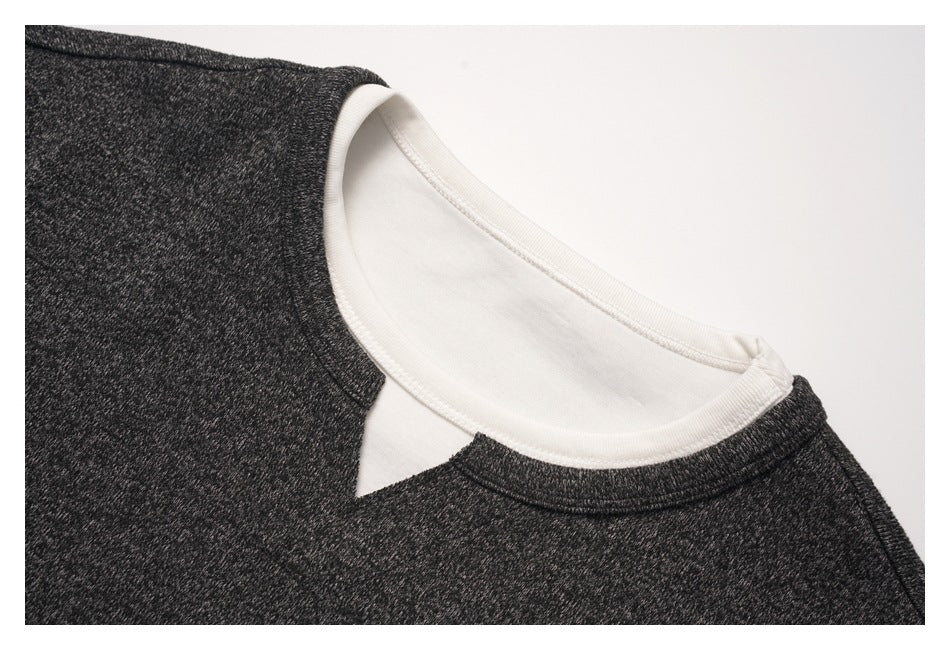 Close-up of a charcoal heather shirt neckline with a white inner layer showing beneath the collar.