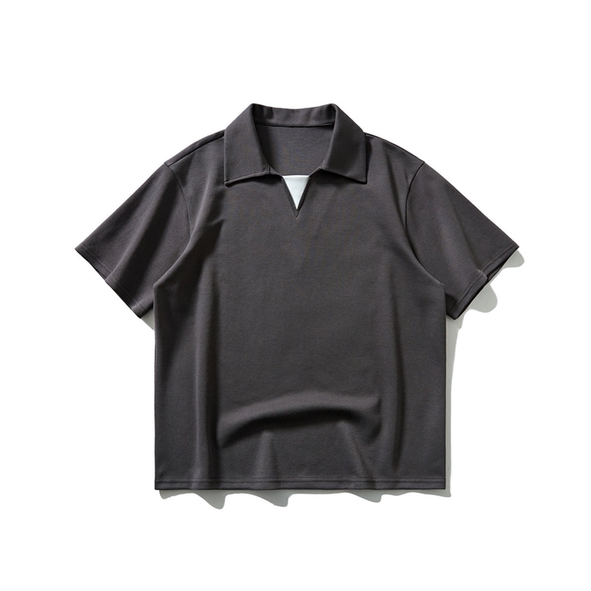 Dark charcoal short-sleeve polo shirt with collar and V neckline with white inset, flat lay front view