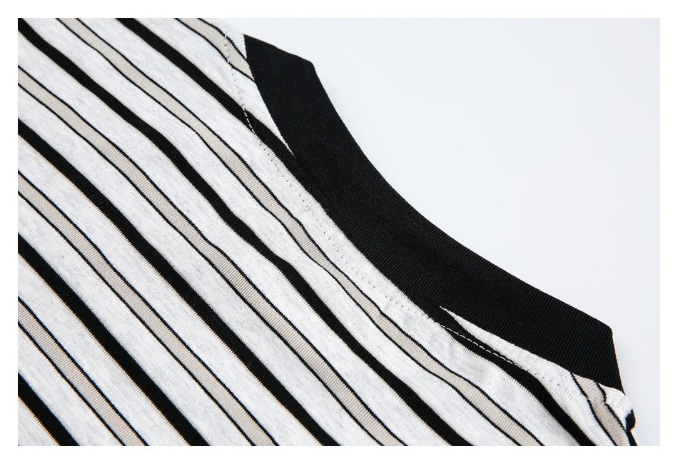Close-up of the black crew neck and shoulder seam on a white shirt with black stripes.