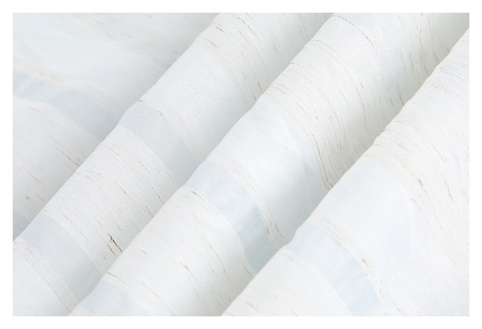 Close-up of folded white fabric showing fine beige streaks and sheer woven bands.