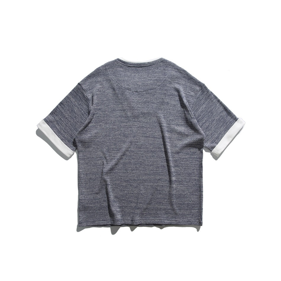 Back view of a blue-gray textured short-sleeve shirt with white sleeve cuffs.